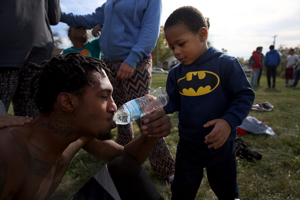 Marques Thorpe Jr., 3, helps his dad rehydrate